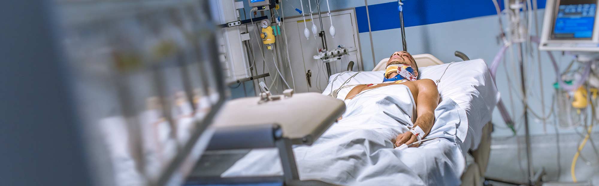 Person lies in hospital bed after being heavily injured in a car accident.