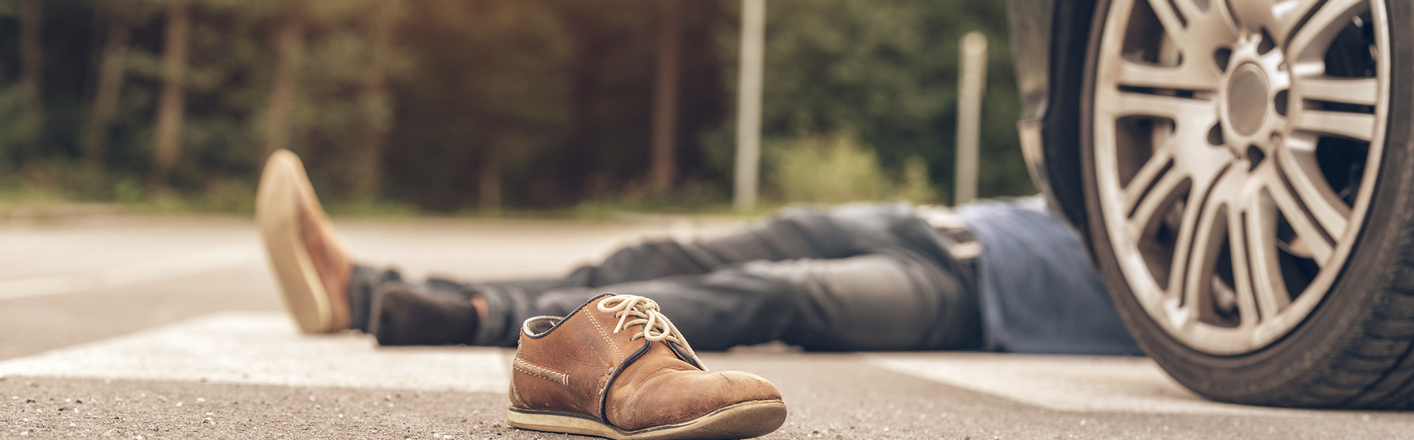 Pedestrian lies on the street after being struck by a car.