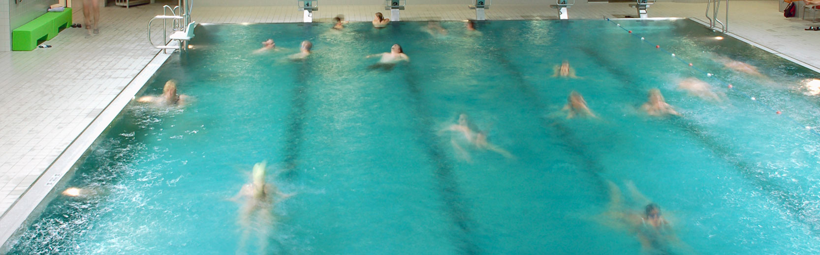 image of a large public pool with people swimming